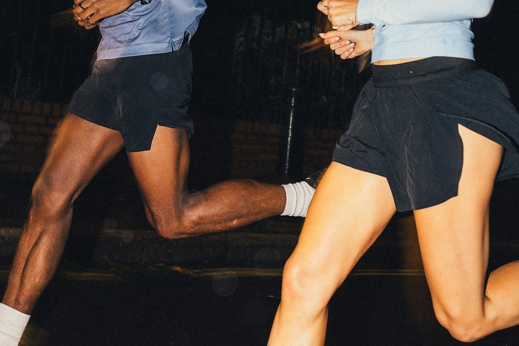 Two people running at night on a dark road.